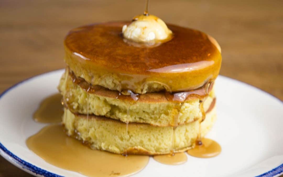 stack of griddle cakes with butter and syrup